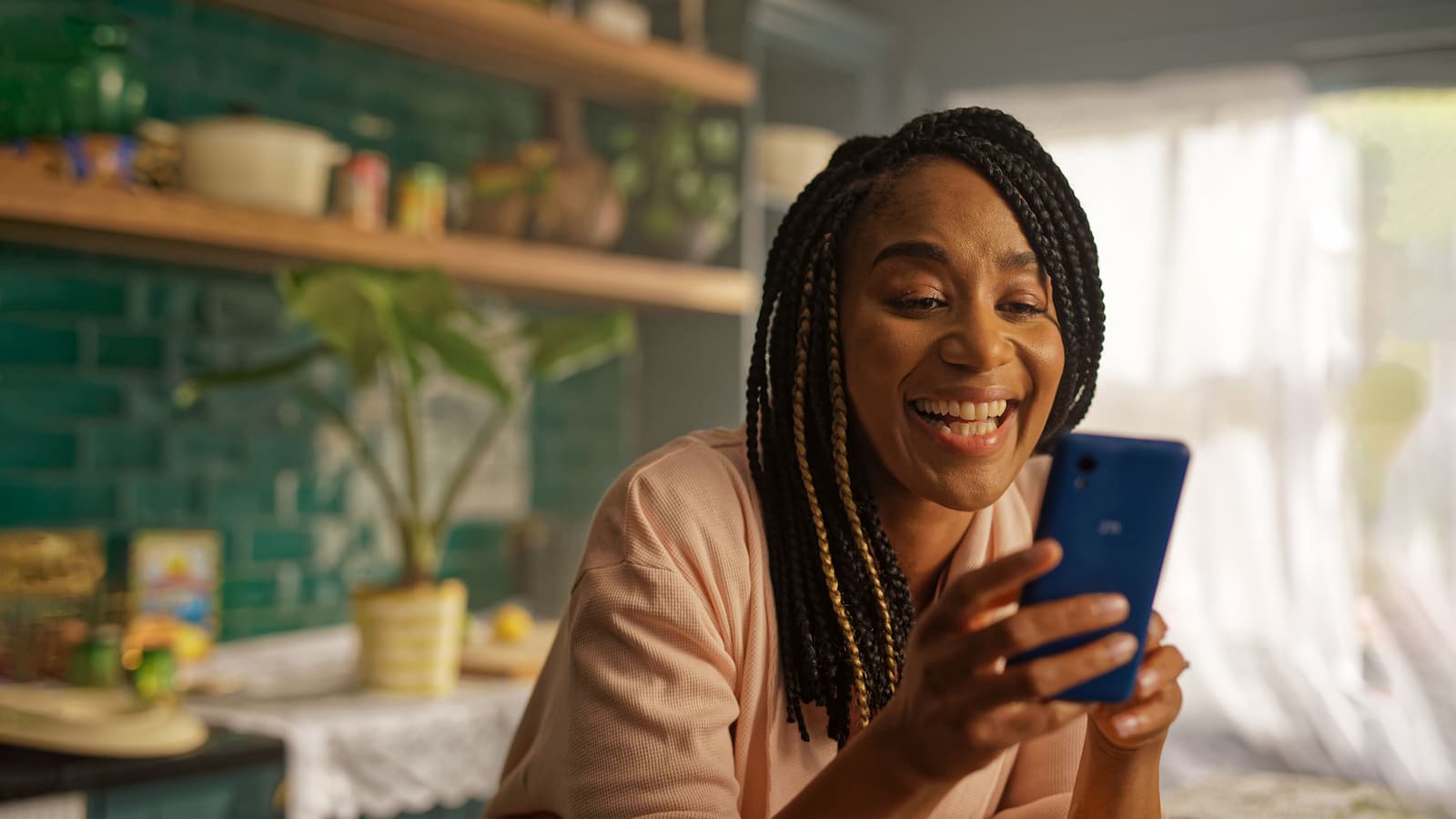 TV Commercial Still A woman looking at her phone and smiling