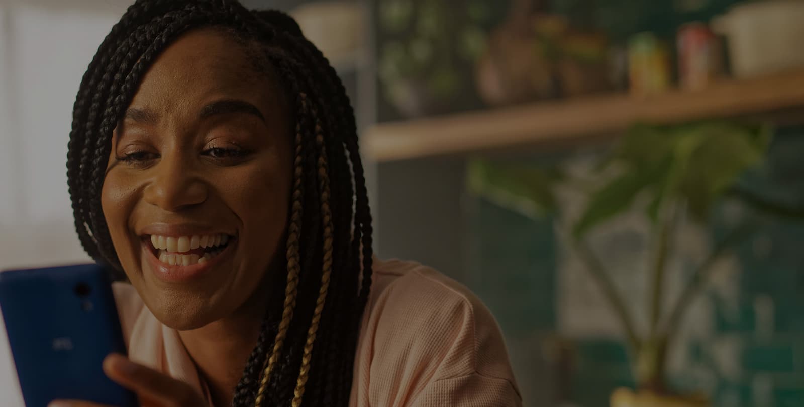 herohomepage An image of a lady smiling, whilst using her phone