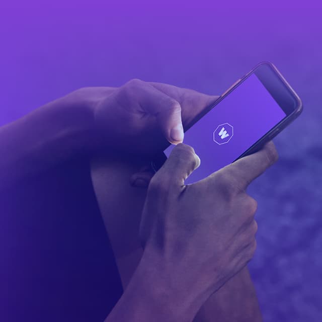 Promo Banner - Mobile A close-up image of the hands of someone holding a smartphone with the WorldRemit logo displayed